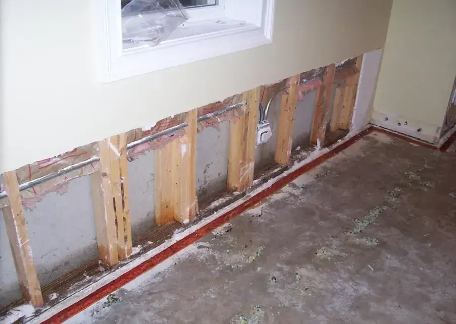 Lower drywall cut away to the studs during water damage cleanup, tack strip still on the floor