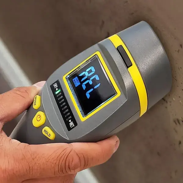 Pinless moisture meter held against a wet surface during a Riverton dry-out
