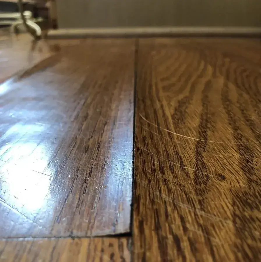 Hardwood boards cupped and lifted at a seam from water underneath