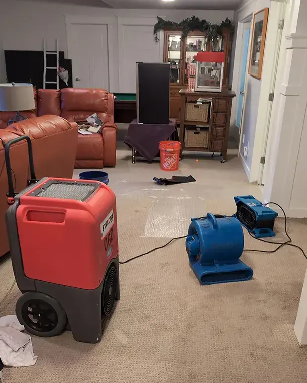 Dehumidifier and air movers drying a Riverton family room with the carpet pulled up