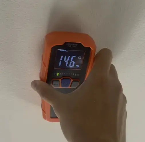 Moisture meter reading a damp wall during a Riverton dry-out
