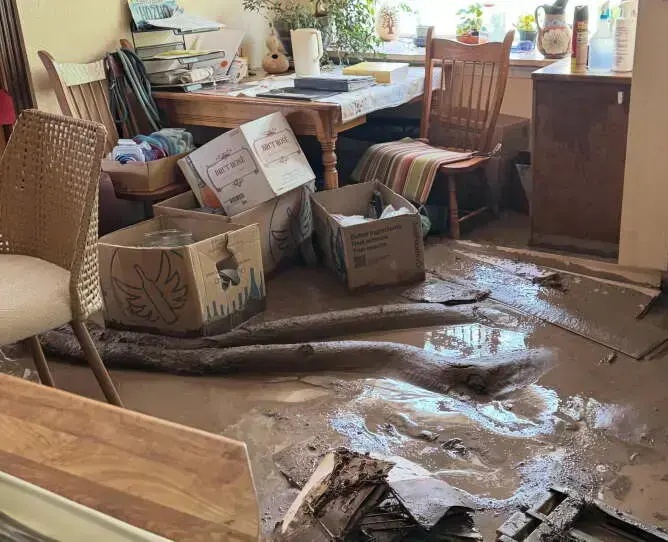 Mud and floodwater across a room floor after a flash flood, ready for cleanup in Riverton
