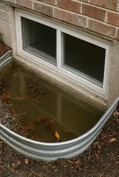 Rainwater and leaves pooled in a window well outside a basement window in Riverton, UT